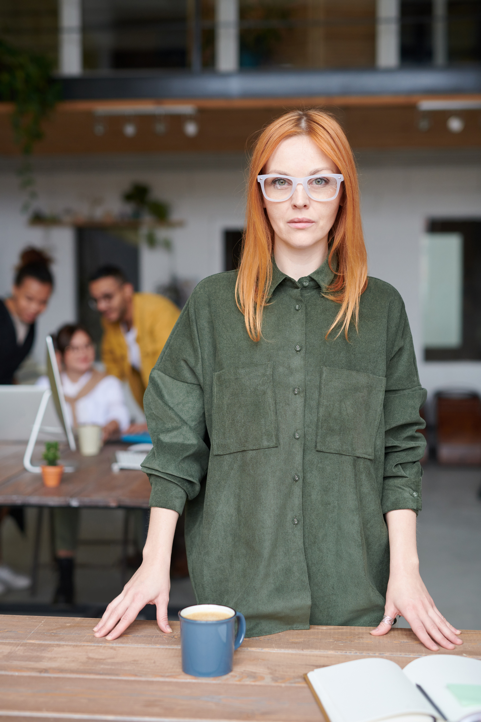 Young businesswoman in the office with colleagues in the background